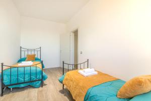 two twin beds in a room with white walls at The Purple House between Modena and the Ferrari Museum in Modena