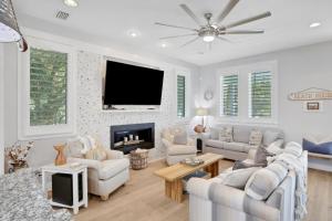 a living room with white furniture and a flat screen tv at A Better Place in Carillon Beach