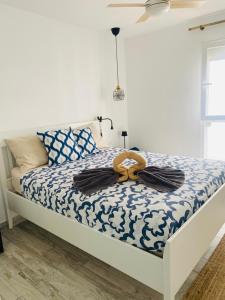 Un dormitorio con una cama con un edredón azul y blanco. en TULUM MEDANO BEACH, en El Médano