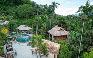 a resort with a pool and chairs and trees at Asia Tropical Resort and Spa in Làng Coc