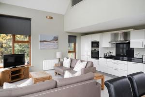 a living room with a couch and a tv at The Salthouse Lodges in Ballycastle