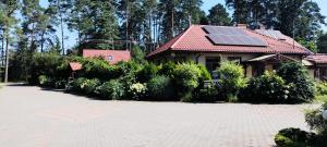 a house with a roof with solar panels on it at Noclegi, Pokoje Gościnne, Wyżywienie, Catering, AGRO ELA in Wydmusy +4 photos