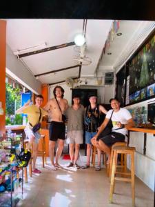 a group of men posing for a picture in a bar at Voyagers Hostel in Phi Phi Islands