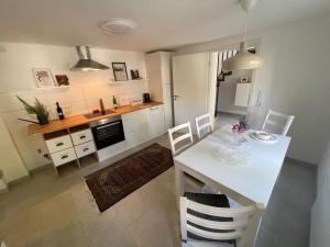 a kitchen with a white table and white chairs at Ferienwohnung Utes Stube in Neuwied