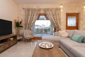 a living room with a couch and a table at Aurum Luxury Villa Voz by elite" in Laganas