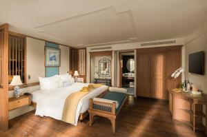 a bedroom with a large white bed and a desk at Bhaya Soul Cruise in Ha Long