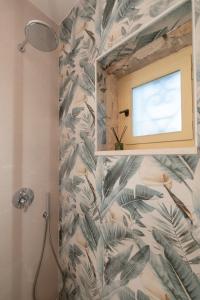 een badkamer met een douche met tropisch behang bij Aurum Luxury Villa Voz by elite" in Laganas