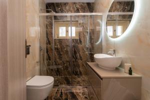 een badkamer met een toilet, een wastafel en een spiegel bij Aurum Luxury Villa Voz by elite" in Laganas +55 foto's