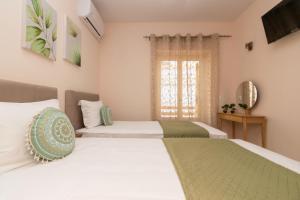 een slaapkamer met twee bedden en een raam bij Aurum Luxury Villa Voz by elite" in Laganas