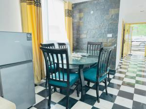 a dining room with a table and four chairs at The Masken Murree in Murree