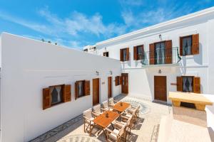 an outdoor patio with a wooden table and chairs at Villa Eftihia in Lindos in Líndos