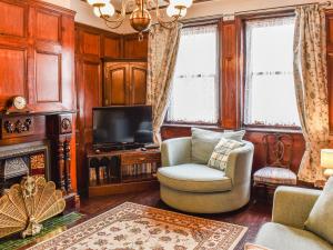 a living room with a chair and a television at Heritage Lodge in Rhyl