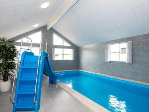a swimming pool with a blue slide in a room at Luxury Retreat in Mommark - By Traum Ferienwohnungen in Sarup