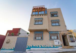 a building with a sign on top of it at Bella Vista Surf Camp in Tamraght Ou Fella