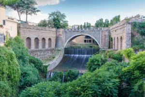 a stone bridge with a waterfall in front at Antica Tibur in Tivoli