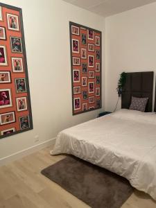 a bedroom with a bed and pictures on the wall at Petite maison à coté de Beauval & Chateaux in Meusnes +28 photos