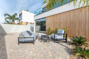a patio with two chairs and a couch and a table at Villa Memorias by Algarve Holidays in Páteo