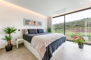 a bedroom with a bed and a large window at Villa Memorias by Algarve Holidays in Páteo +37 photos