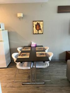 a black table with white chairs in a room at Silver Luxury 6 in Poiana Brasov
