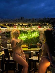two women in bikinis standing in front of a bar at Tan Y Bryn Glamping in Conwy