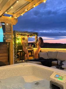 two women in bathing suits sitting next to a swimming pool at Tan Y Bryn Glamping in Conwy +251 photos