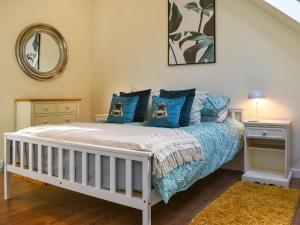 a bedroom with a white bed with blue pillows at Garden Studio in St Austell +10 photos