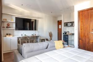 ein Wohnzimmer mit Couch und Küche in der Unterkunft Flat prox. MASP e Av. Paulista - Limpeza Diária in São Paulo