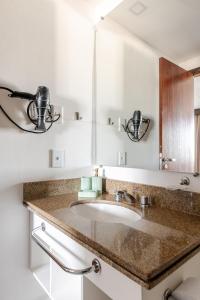 ein Badezimmer mit Waschbecken und Spiegel in der Unterkunft Flat prox. MASP e Av. Paulista - Limpeza Diária in São Paulo