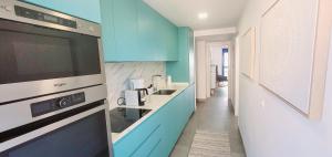 a kitchen with blue and white walls and a sink at Blue Beach Apartment in Ifach