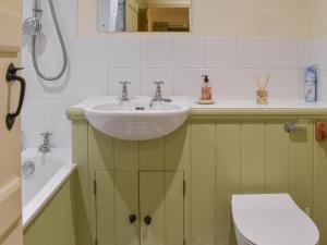 a bathroom with a sink and a toilet at Honeysuckle Cottage in North Mundham