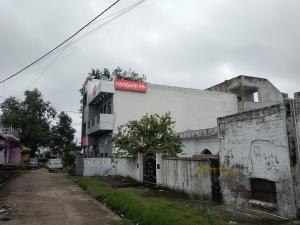 a white building with a red sign on it at Harigarh Inn in Alīgarh