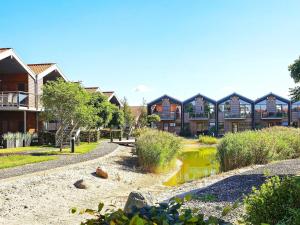 a row of houses with a pond in a park at 4 person holiday home in Bogense-By Traum in Bogense