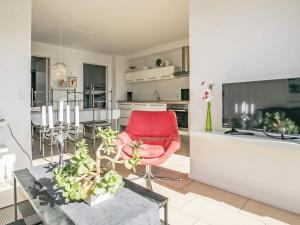 a living room with a red chair and a table at 4 person holiday home in Bogense-By Traum in Bogense +25 photos