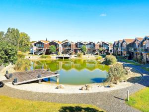 a park with a pond with houses in the background at 4 person holiday home in Bogense-By Traum in Bogense