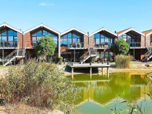 a building with a pond in front of it at 4 person holiday home in Bogense-By Traum in Bogense