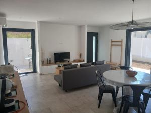a living room with a couch and a table at charmante maison neuve proche plage et commerces in Calvi