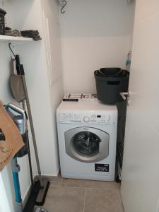 a washing machine with a bucket on top of it at charmante maison neuve proche plage et commerces in Calvi +6 photos