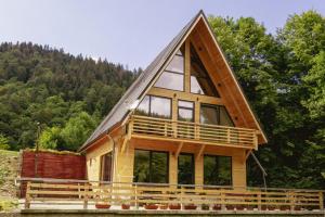 a frame house with a gambrel roof at Chalet Green in Cazaci