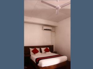 a bedroom with a bed with red pillows and a ceiling at 256 Townhouse Rest in Kandy