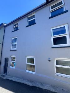 a white house with windows and a door at 4 Bedroom All En suite Central Townhouse Ideal for Groups in Builth Wells