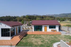 a home with a large deck and a house at Gyeongju Bulguksa Family House Stay Mute in Gyeongju