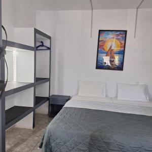 a bedroom with a bed and a painting on the wall at Petite Economy Lodge in Skiathos +162 photos