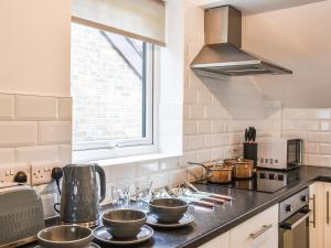 a kitchen with a counter top with bowls on it at Sheep's View Cottage in Eastbourne