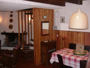 a dining room with a table and a room with a fireplace at Baita Amiata in Monte Amiata