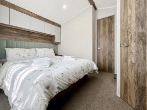 une chambre avec un grand lit blanc avec une tête de lit en bois dans l'établissement Brookwood, à Weston-super-Mare