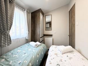 une chambre avec deux lits et une fenêtre dans l'établissement Brookwood, à Weston-super-Mare 9 autres photos