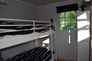 een slaapkamer met twee stapelbedden en een raam bij Kleines Haus Mit Garten, Direkt Hinter Dem Deich in Baarland
