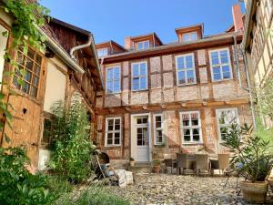 an exterior view of a wooden house with tables and chairs at himmlischer Hof - Juwel von 1477 mit P, romantischer Innenhof, Kamin, Öko, Denkmal in Quedlinburg