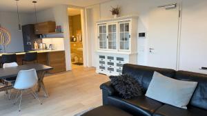 ein Wohnzimmer mit Couch und Tisch und eine Küche in der Unterkunft Spacious apartment with lake view and garden in Richterswil