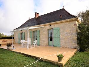 a house with a patio with a table and chairs at Peaceful Stay in Thédirac in Lavercantière